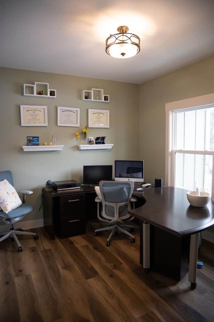 Office workspace with dual monitors and modern furniture.