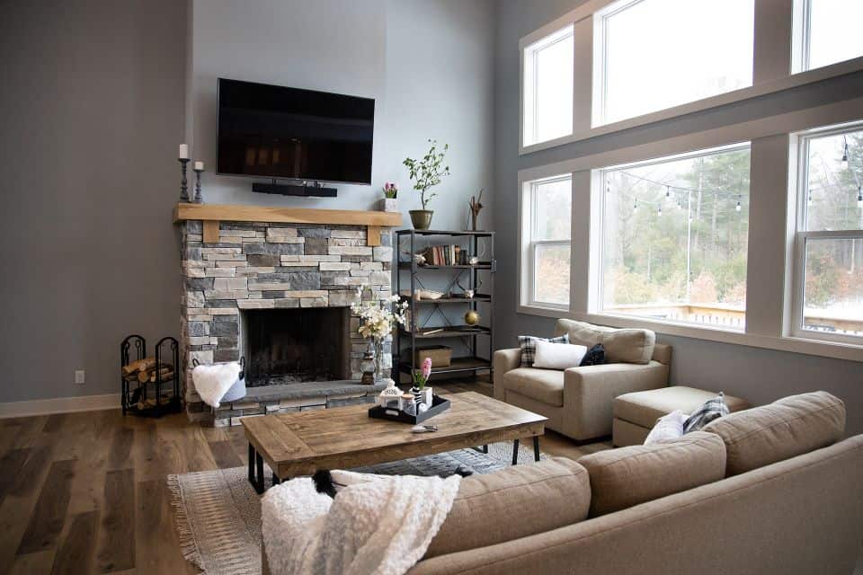 Living room with modern fireplace, large windows, and cozy seating area.