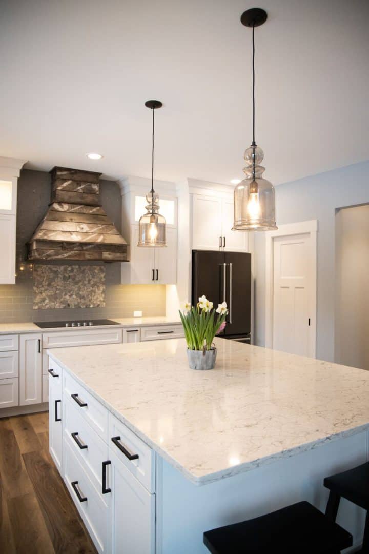 Spacious kitchen featuring a large marble island, pendant lights, and sleek cabinetry for a contempo.