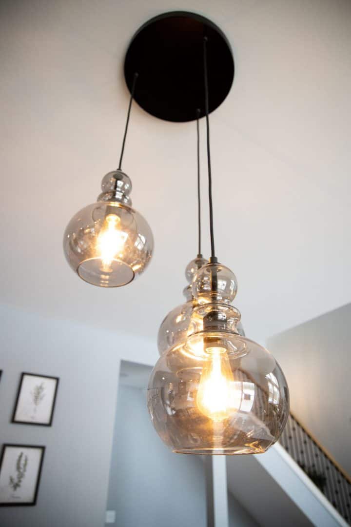 Pendant lighting fixture with glass globes in Livingston Homes interior.