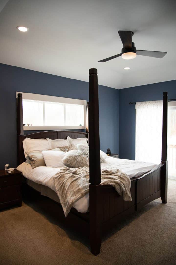 Elegant bedroom with dark wood four-poster bed and cozy bedding.