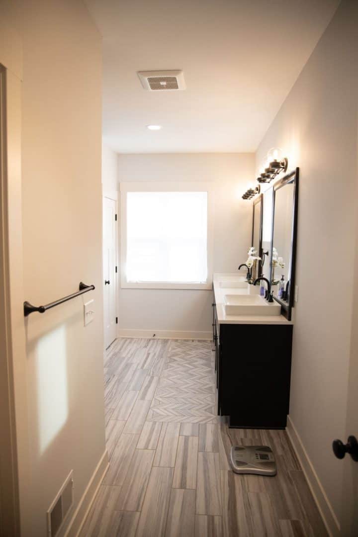 Bathroom with double vanity, large window, and contemporary design.