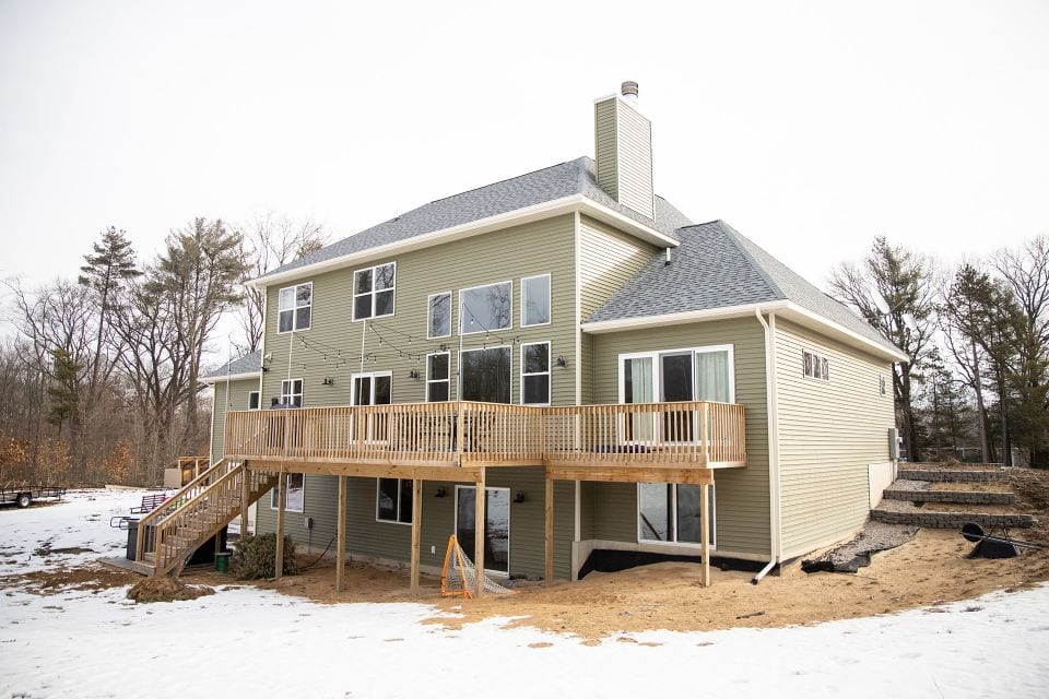 Modern house with spacious deck and large windows.