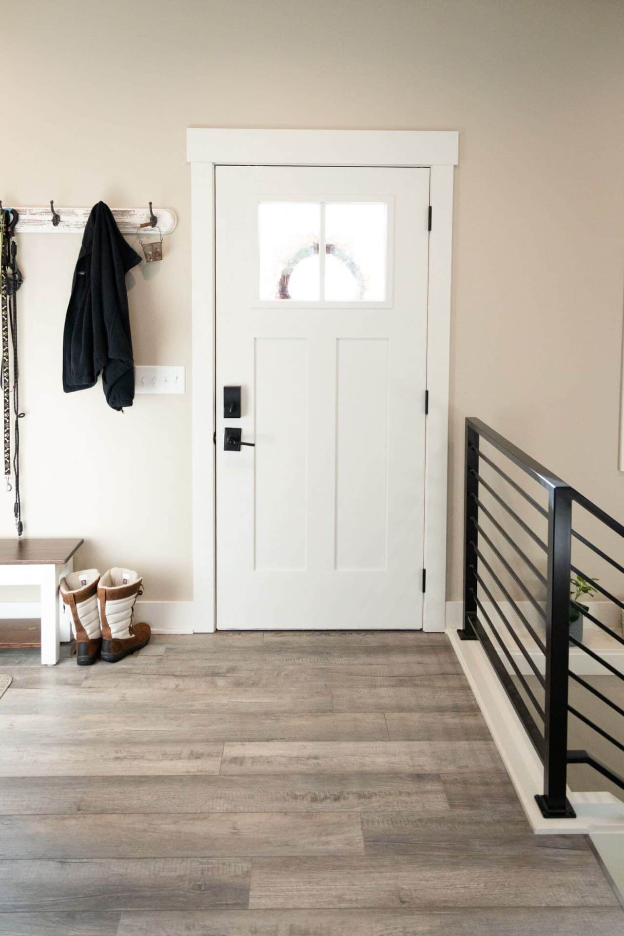 Modern white front door with glass panel and black hardware.