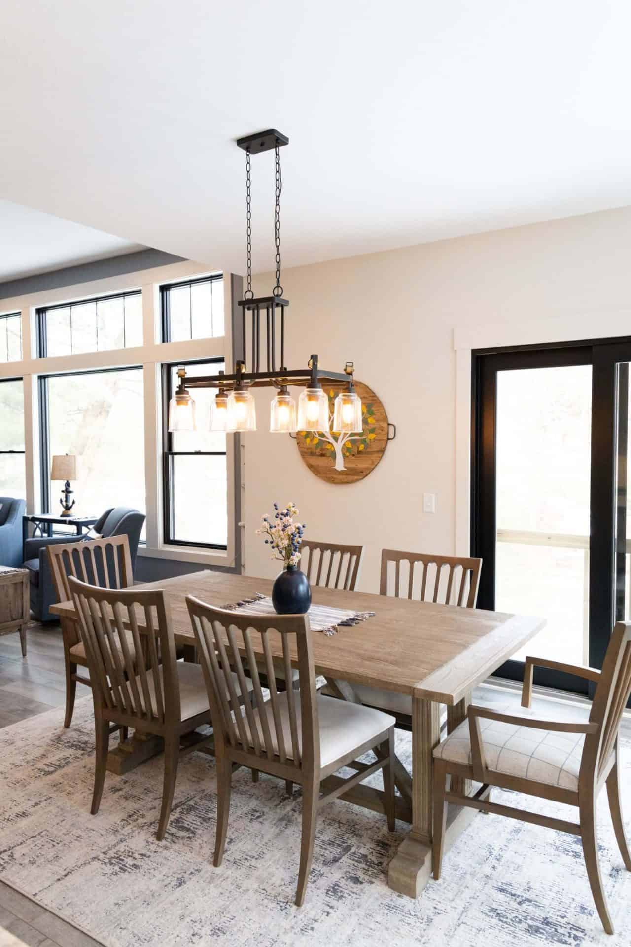 Spacious dining area featuring a wooden table, eight chairs, and large windows for natural light.