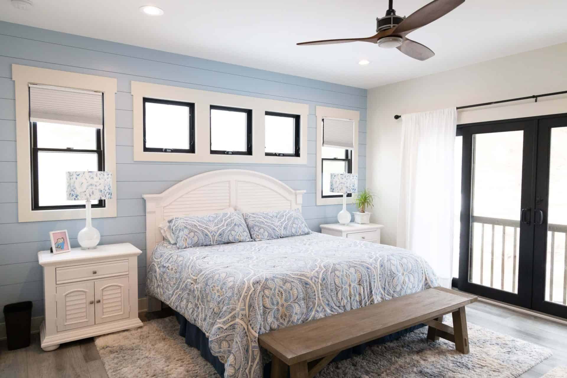 Bedroom with large windows and modern decor.