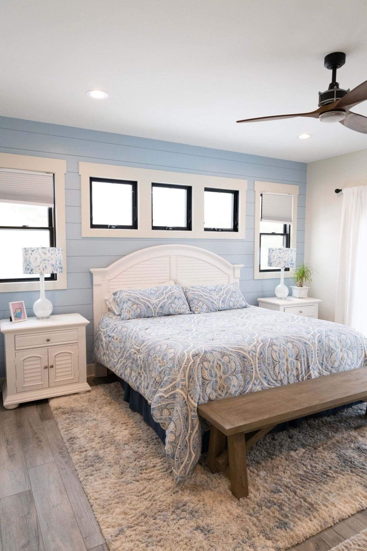 Bright and airy bedroom featuring a white bed, blue walls, and natural light. Perfect for a relaxing.