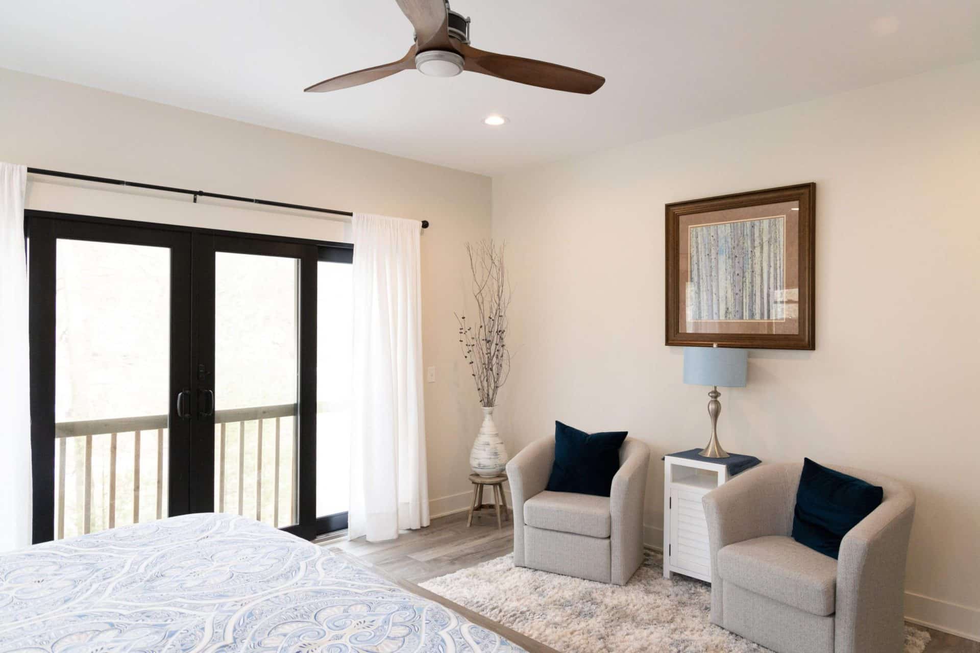 Cozy bedroom with modern decor, sliding glass door, and natural light. Perfect for comfortable livin.
