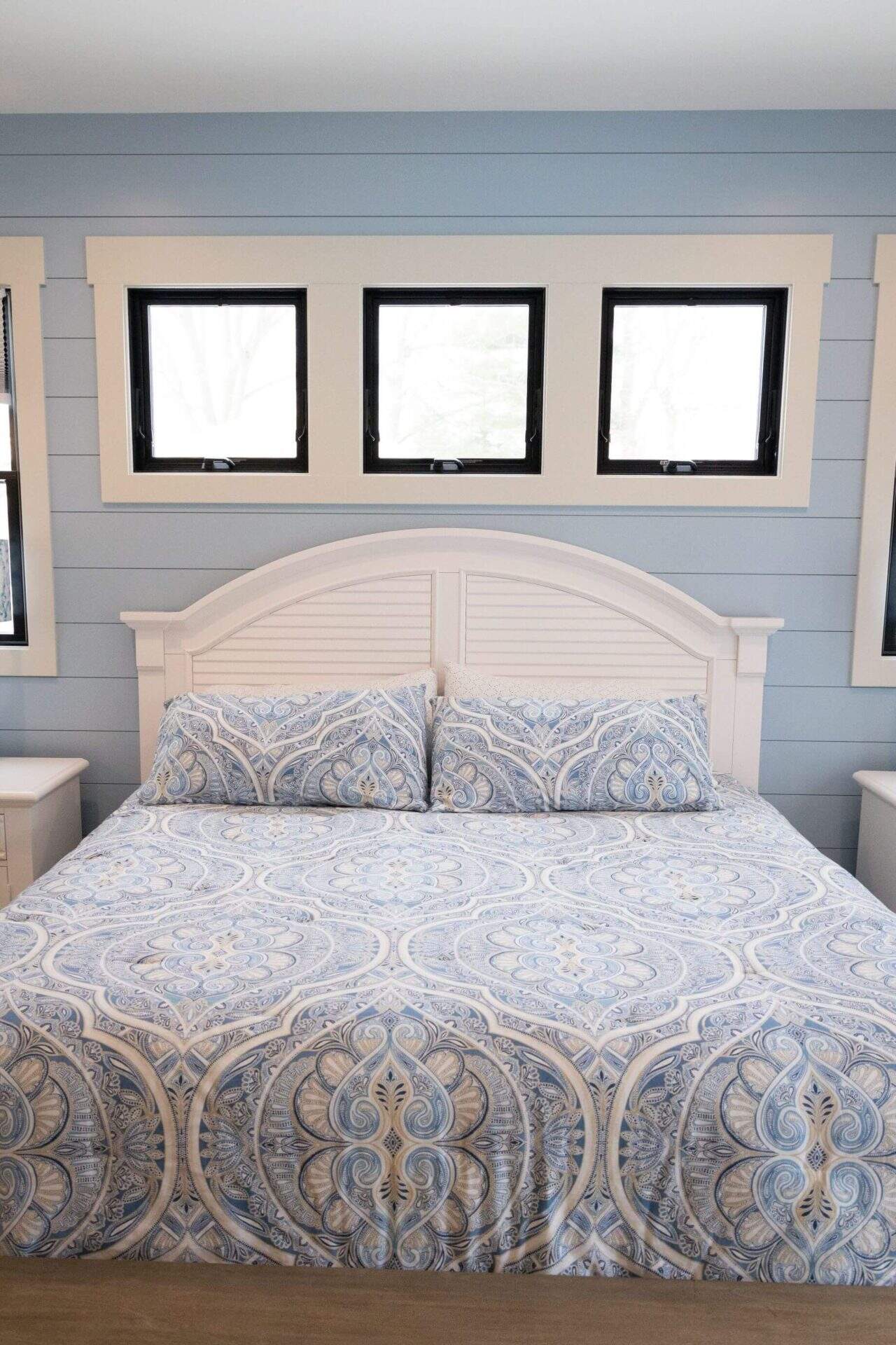 Livingston Homes bedroom with a white bed frame and patterned bedding.