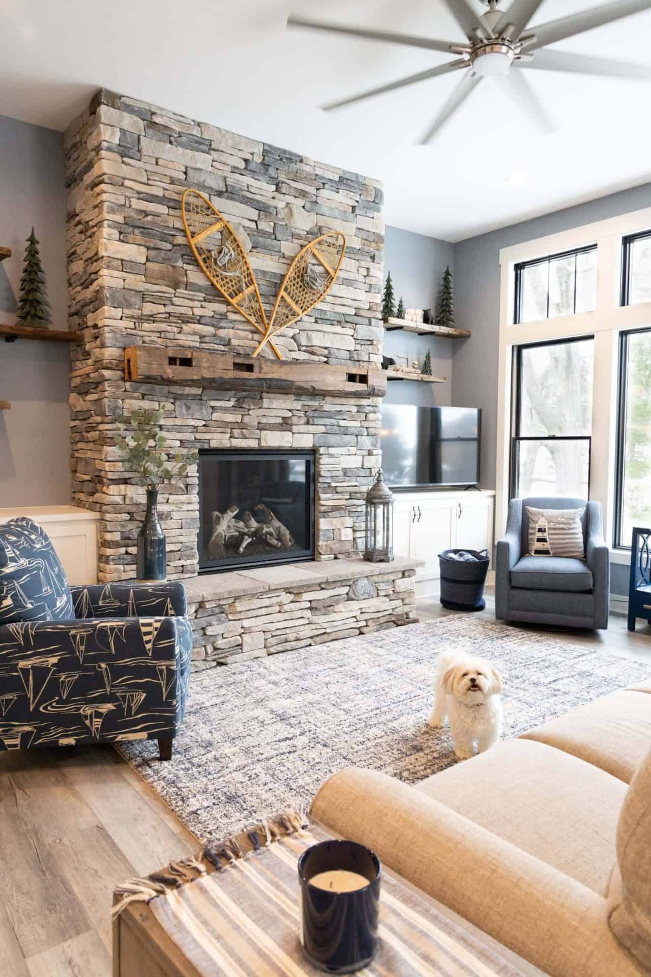 Cozy living room with stone fireplace, modern decor, and large windows for natural light.