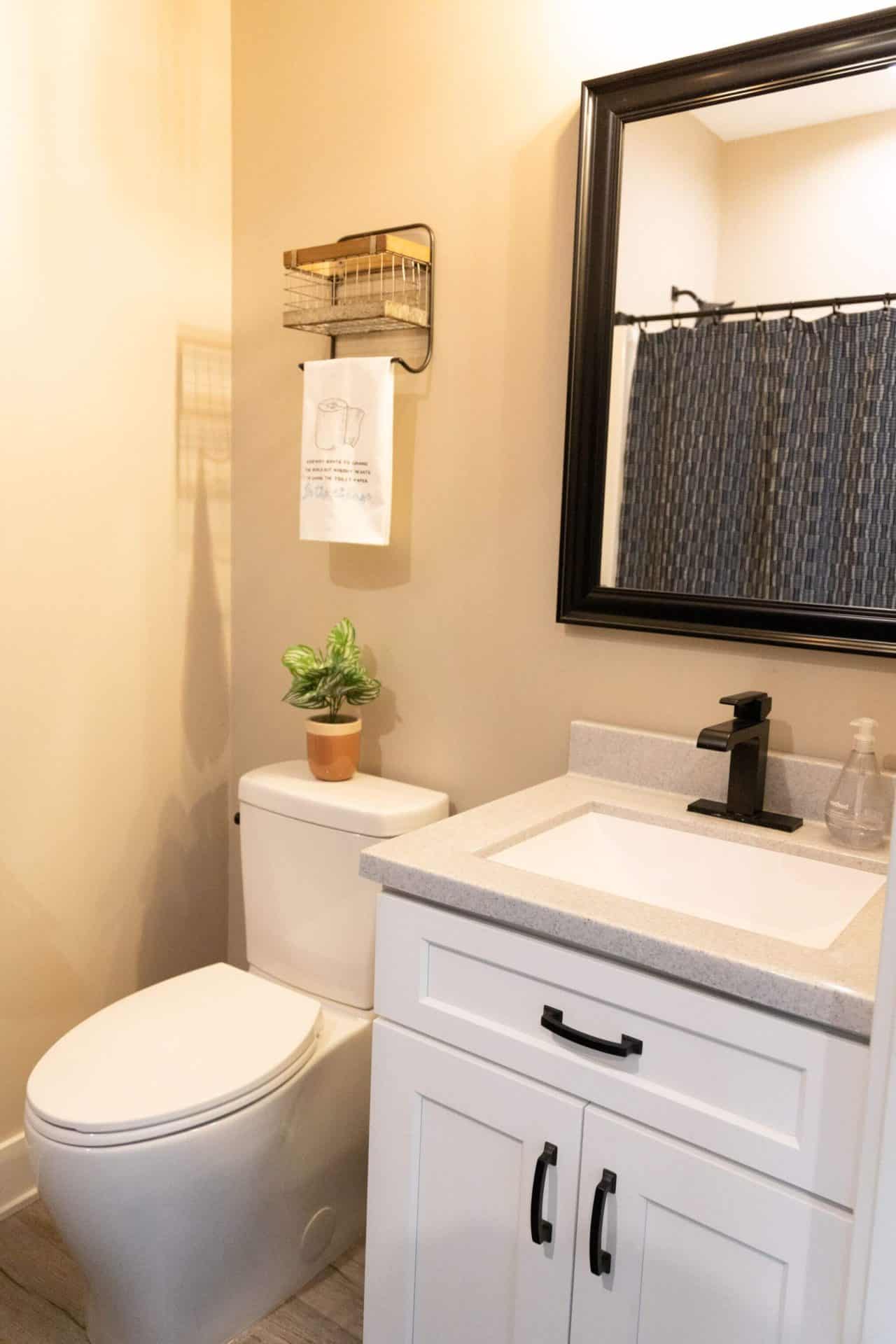 Bathroom with white vanity, black faucet, and mirror in Livingston Homes.