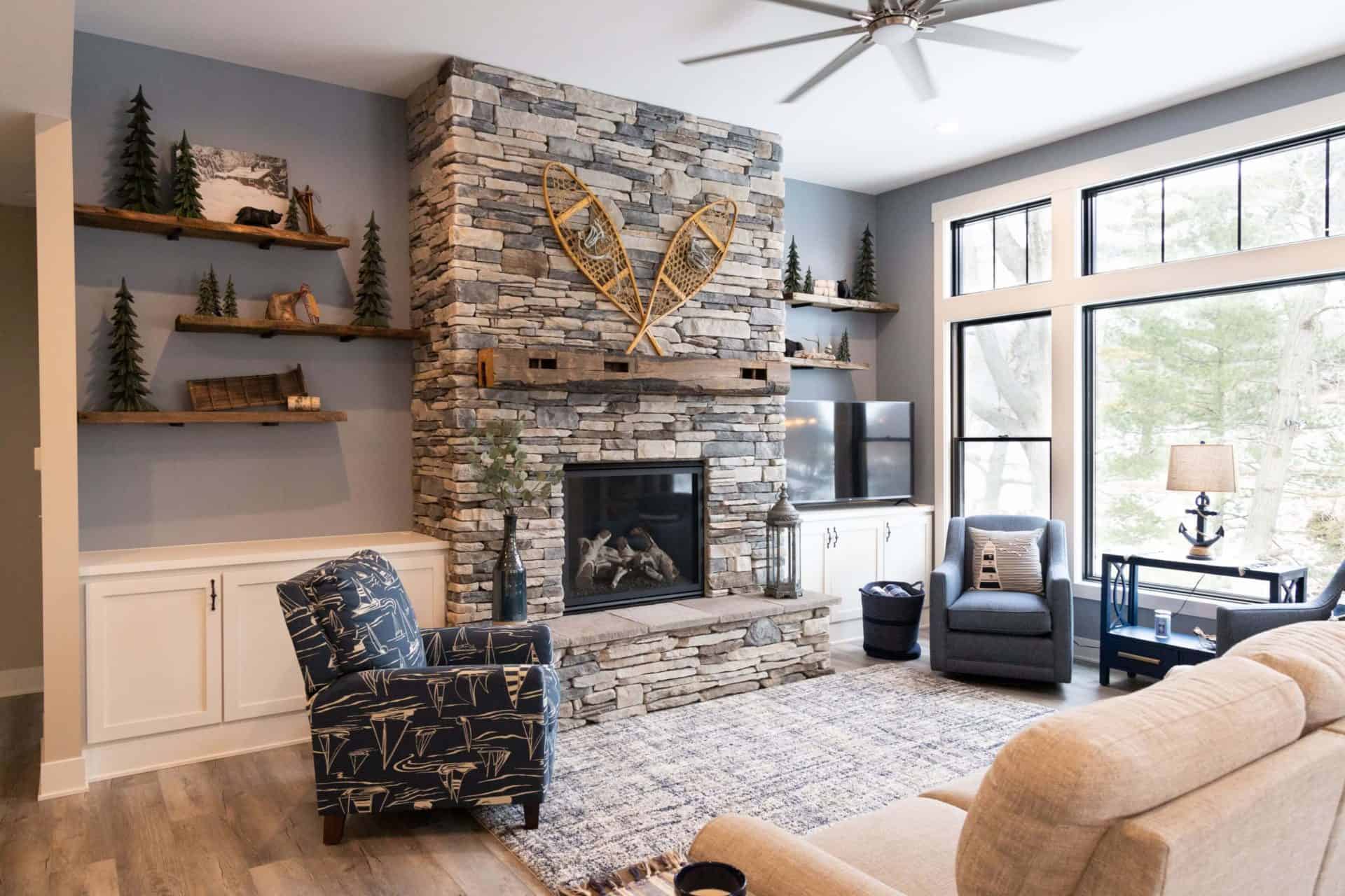 Living room with stone fireplace, modern decor, and large windows.