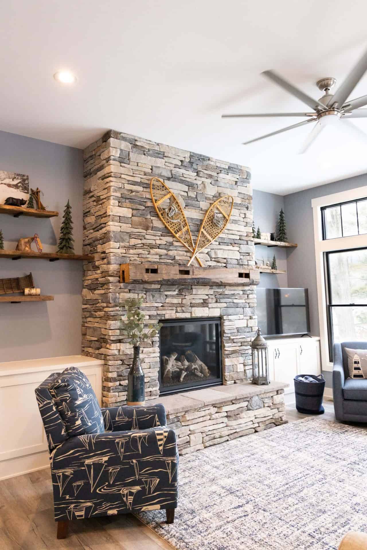 Living room featuring a modern stone fireplace with decorative snowshoes and cozy seating area.