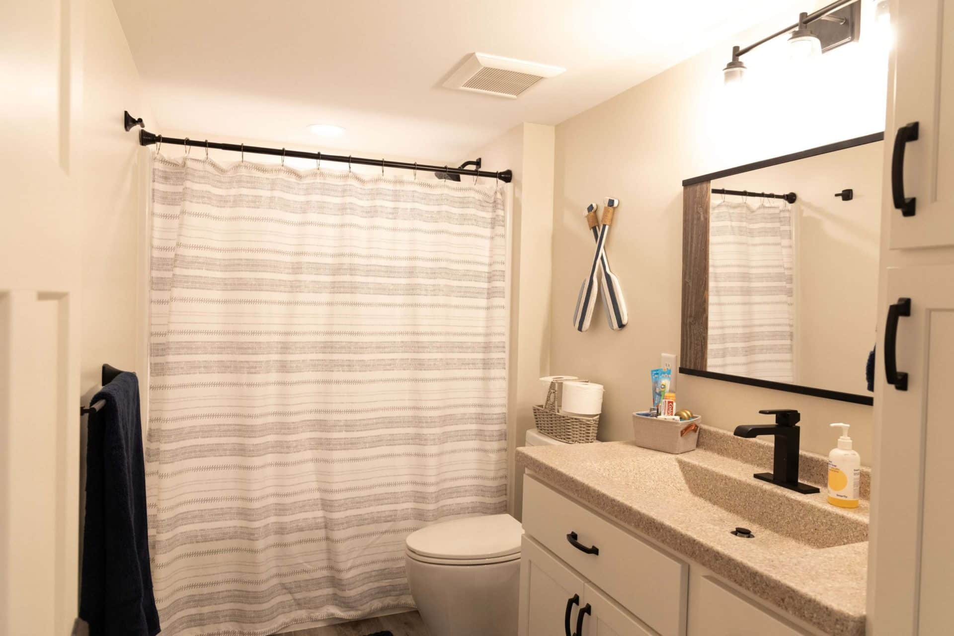 Bathroom with shower curtain, vanity, and mirror in a contemporary home.