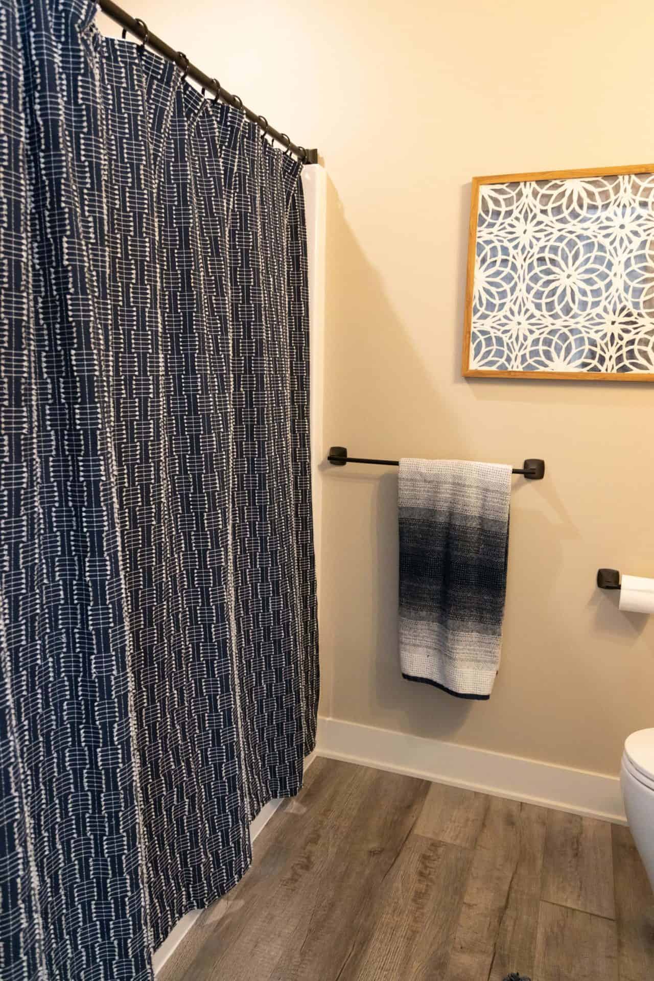 Bathroom with patterned shower curtain and modern decor.