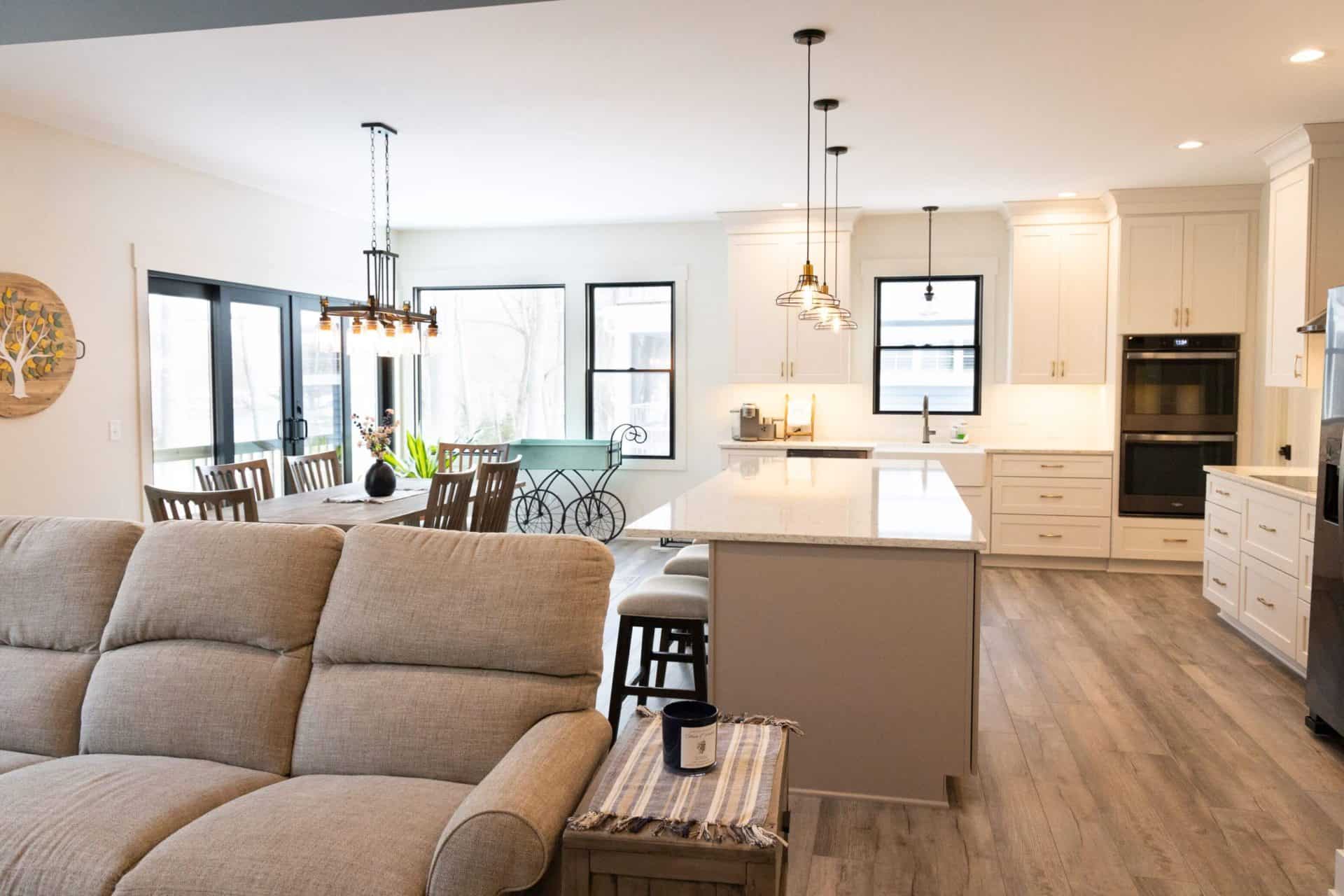 Bright, spacious living room with large windows and contemporary kitchen design.