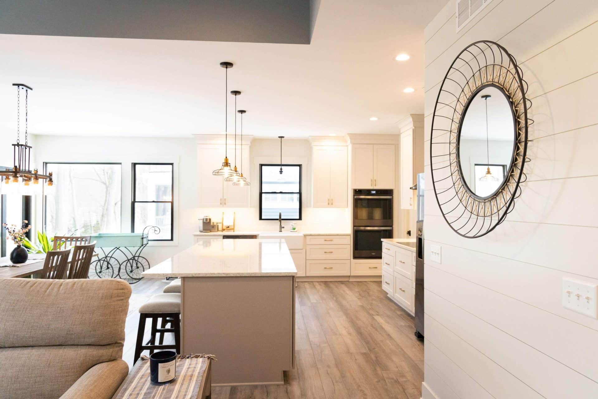 Spacious living area with a bright, modern kitchen featuring white cabinets and a large island. Perf.