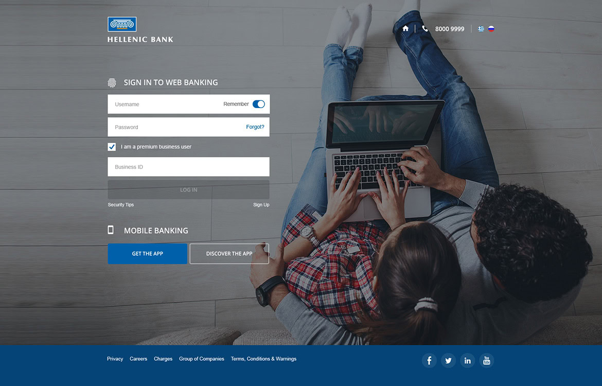 Hellenic Bank online banking login page with a person using a laptop and a mobile device.