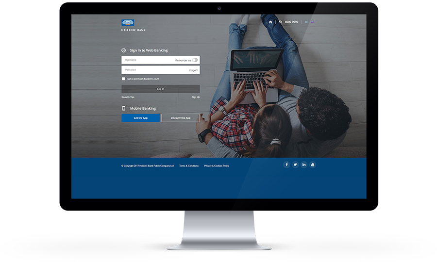 A computer screen displaying a web banking login page with a person using a laptop and a smartphone nearby.