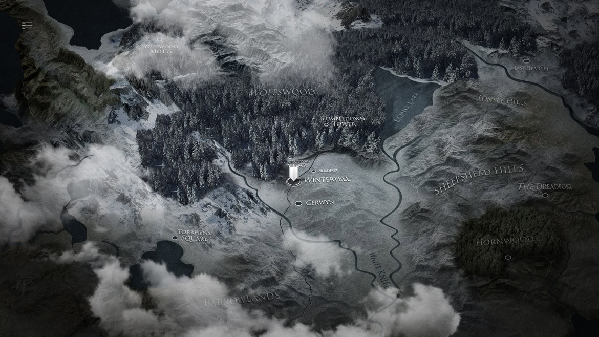 Aerial view of a mountainous landscape with forests, lakes, and winding roads.