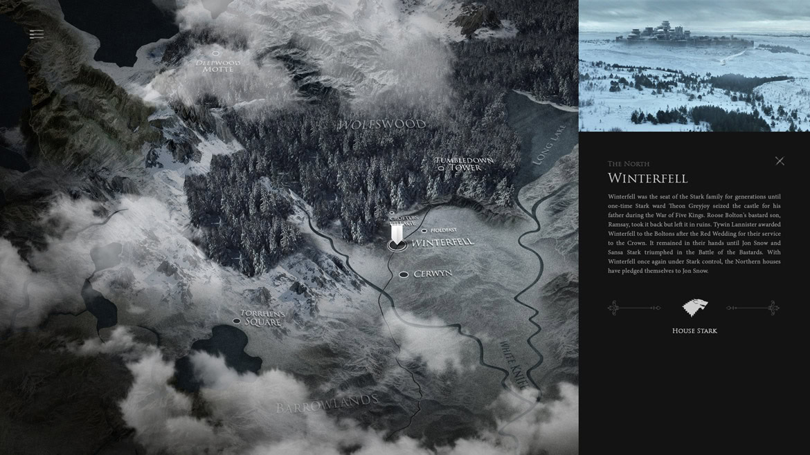 Aerial view of a snowy mountain landscape with forests, a winding road, and a small building.