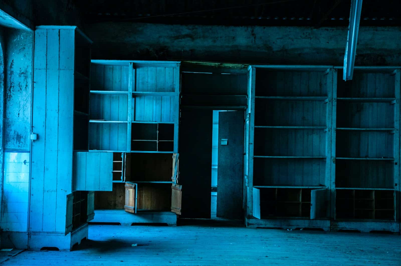 an empty room with a book shelf and a door