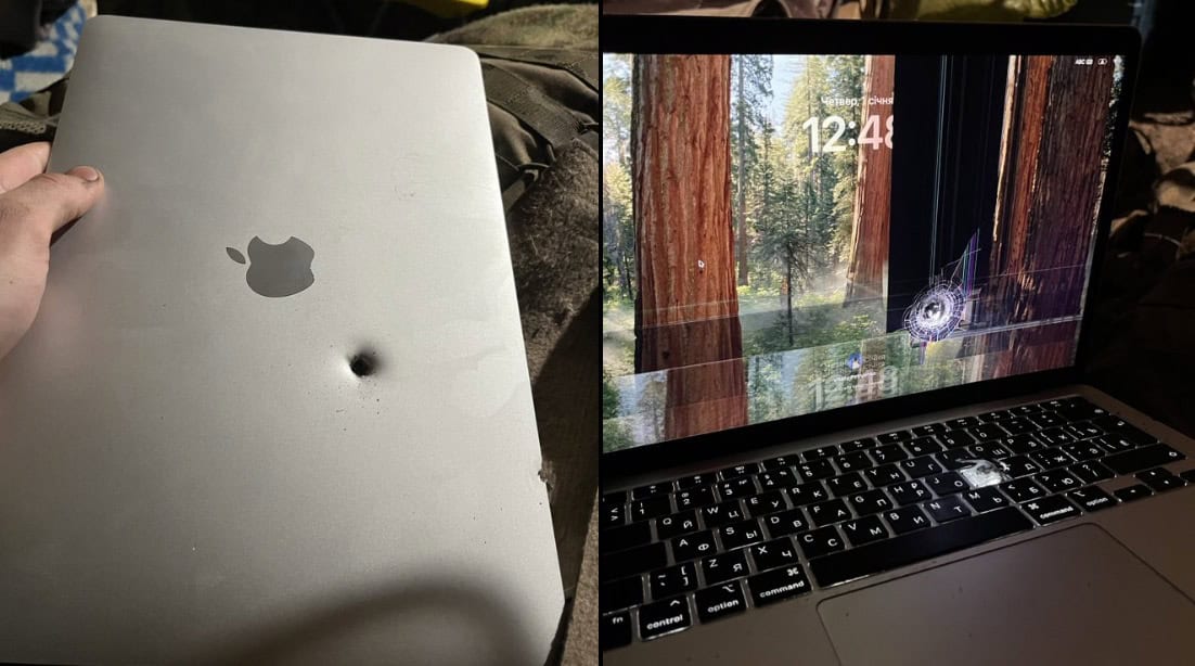 En MacBook med ett stort hål i locket, troligen skadad av ett våldsamt slag eller tillhörande en olycka.