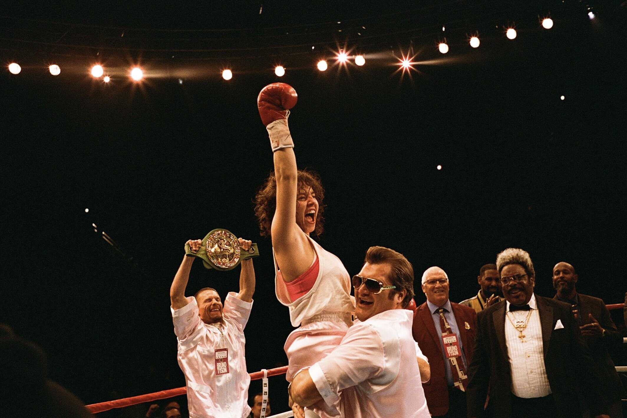 1. Kraftfull boxningsmatch med segerjubel och prisbelöning i en boxingring, med lyktor och jublande publik i bakgrunden.