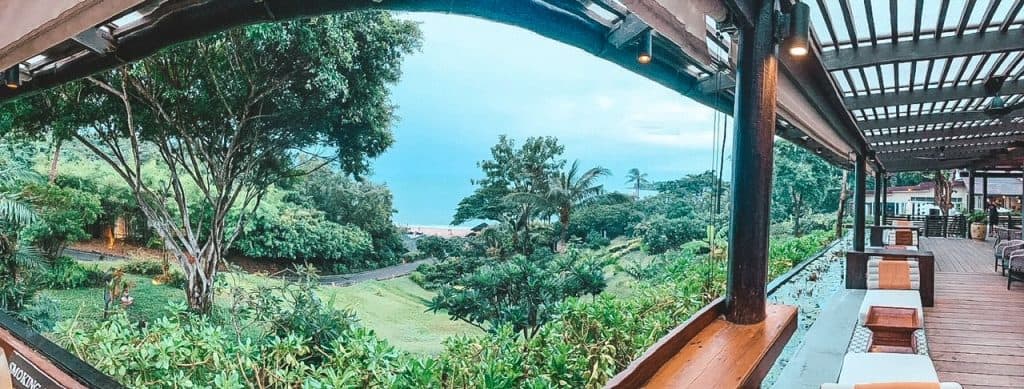 Luxury outdoor lounge with lush green landscape and ocean view in Koh Samui.