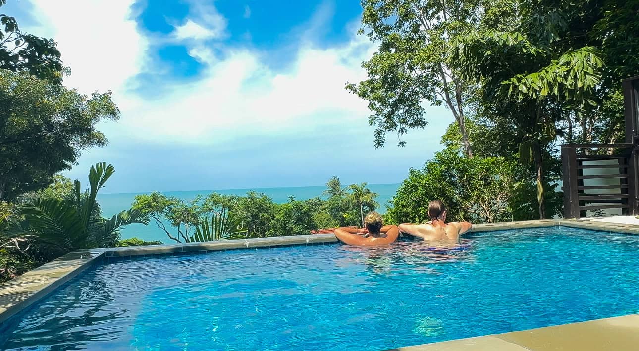 Luxury infinity pool overlooking lush tropical landscape and ocean view.