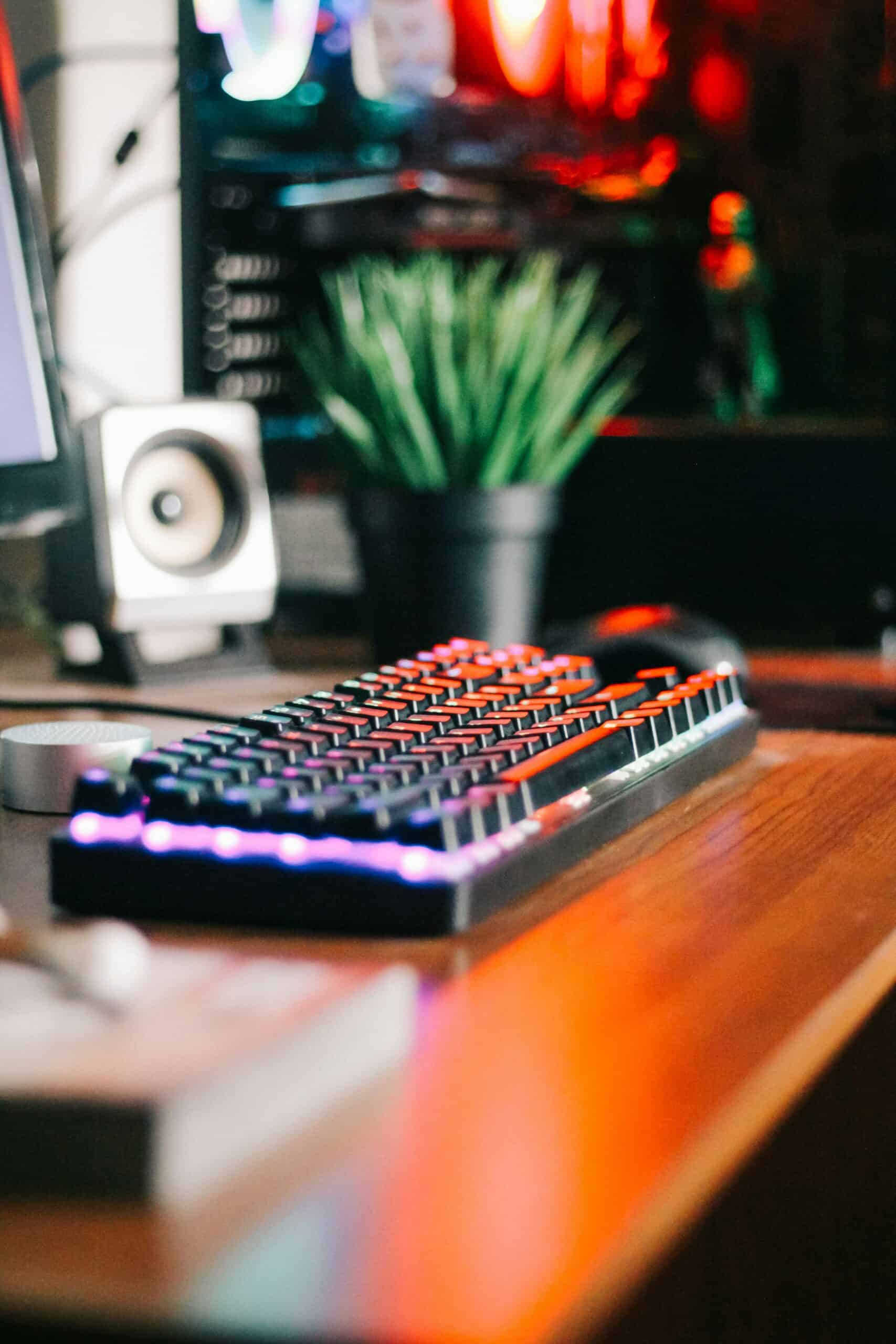 High-end gaming keyboard with RGB lighting on a travel content creator's desk.