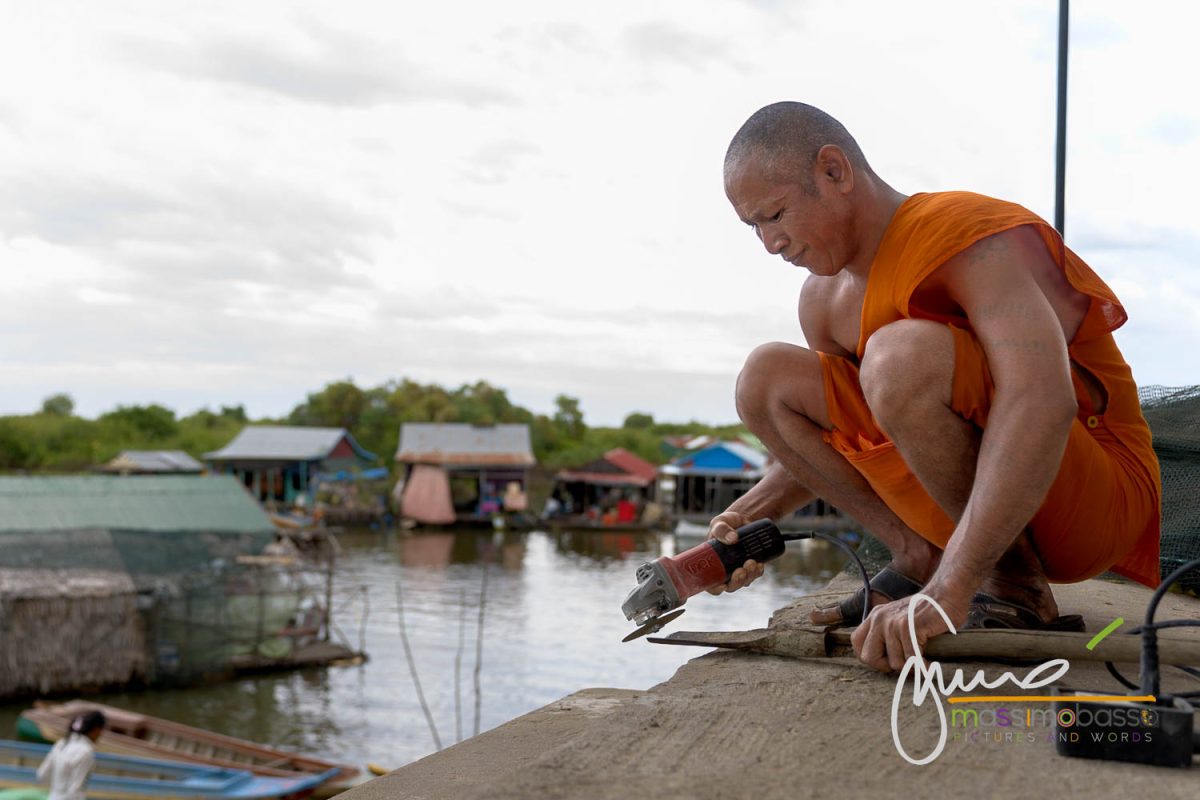 Monaco intento a lavorare alla manutenzione della Pagoda nei pressi di un villaggio galleggiante sul lago Tonlé Sap