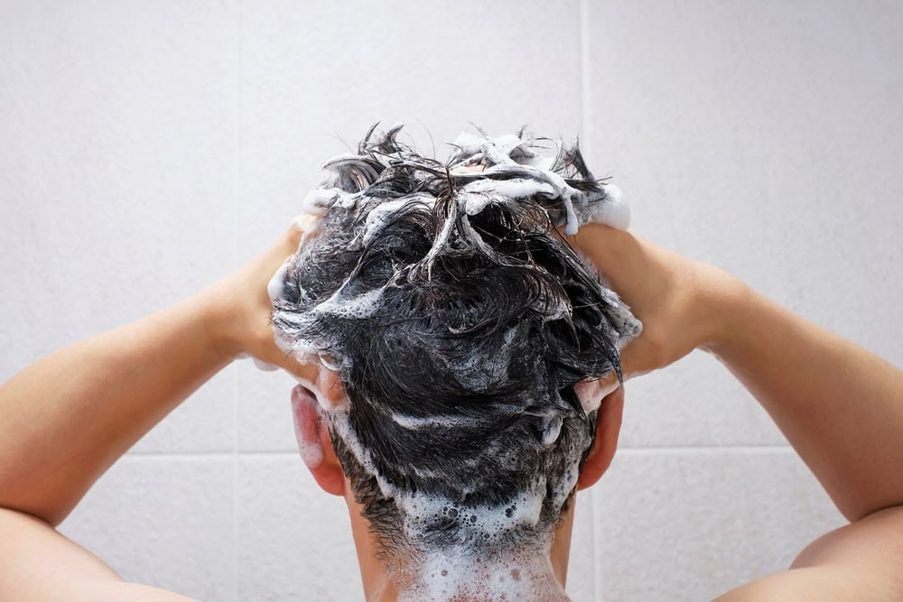 A man using hair care products to prevent a receding hairline