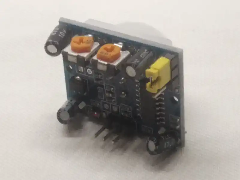 sensor-movimiento-hc-sr501-lateral Vista lateral del sensor de movimiento PIR HC-SR501 con pines de conexión