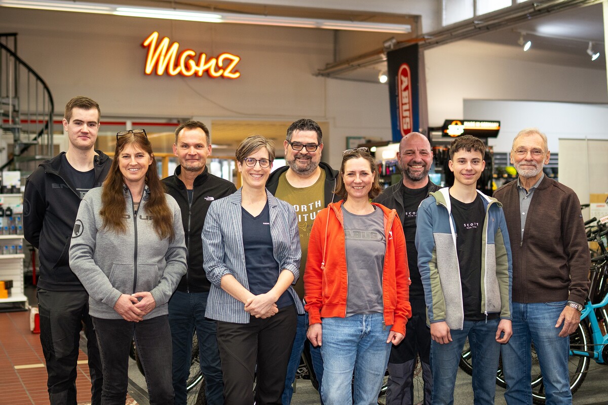 Gruppenfoto von Teammitgliedern in einem modernen Arbeitsumfeld.
