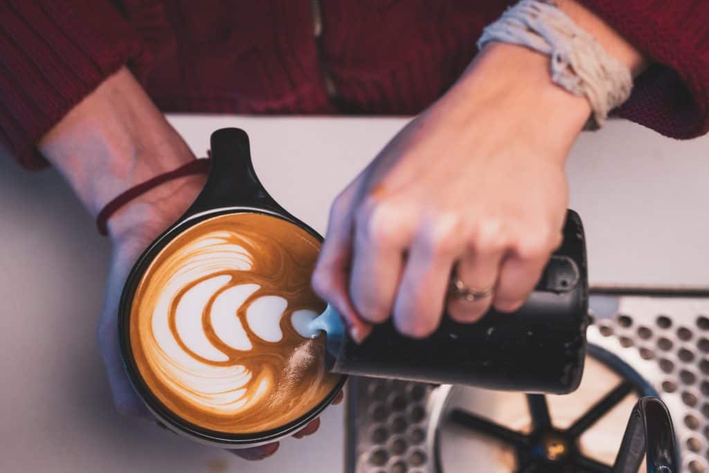 Close-up of a barista creating latte art in a coffee cup at Spring Lake.