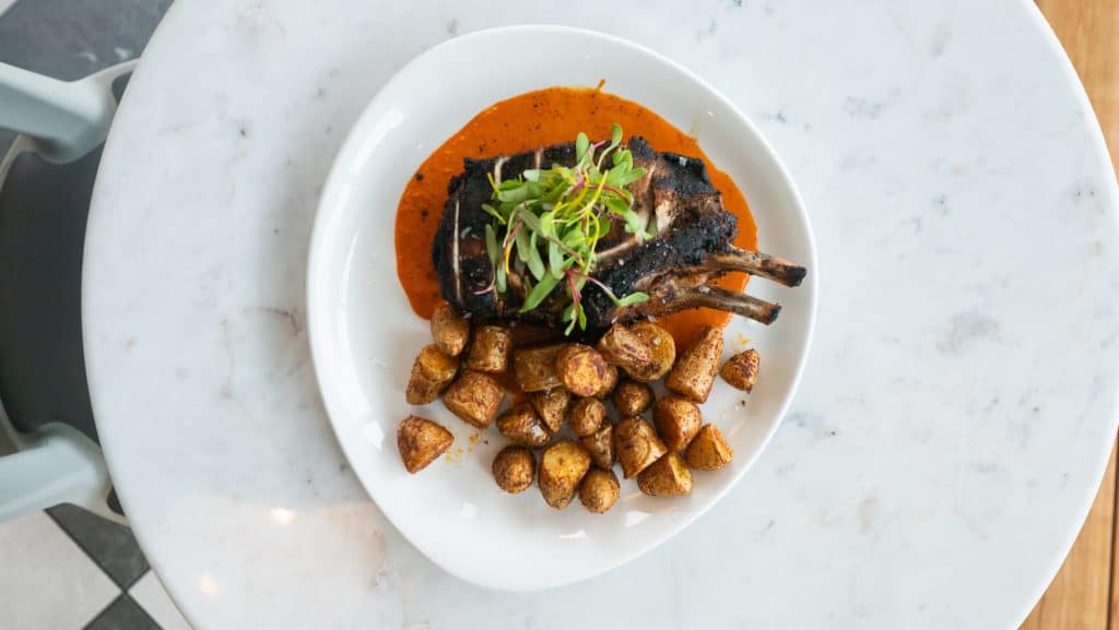 Delicious grilled fish with a rich tomato-based sauce, served with crispy roasted potatoes and fresh.