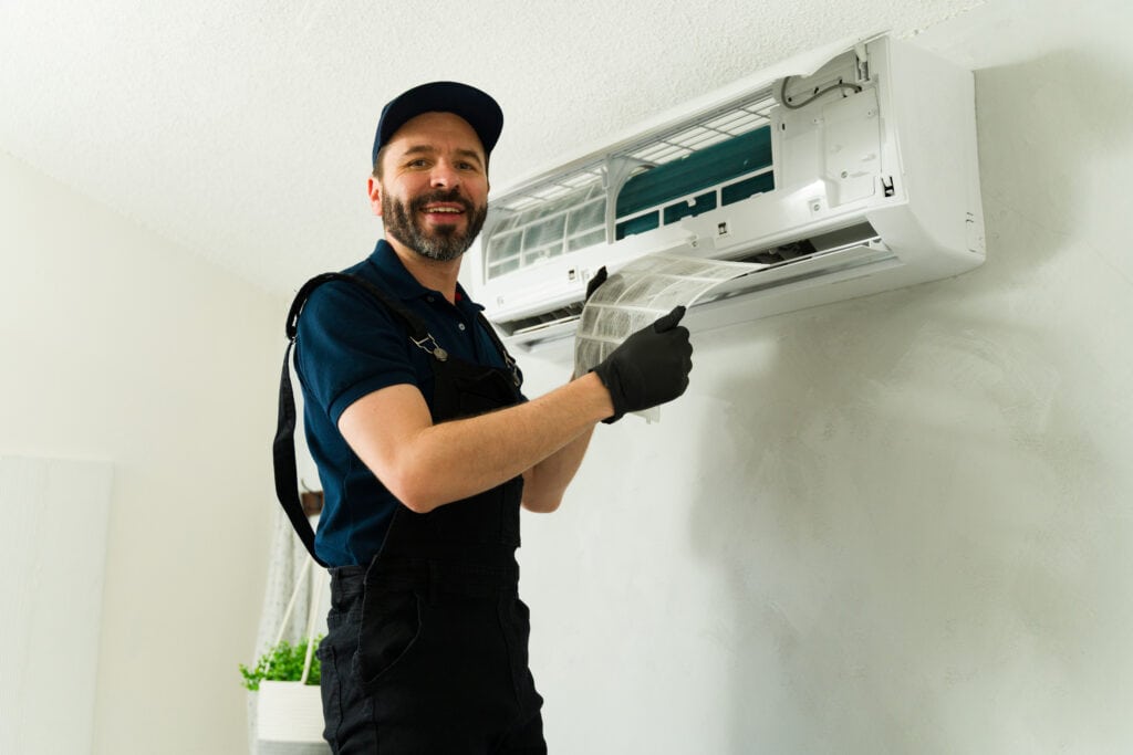 PROFESSIONAL HVAC TECHNICIAN INSTALLING OR SERVICING AIR CONDITIONER, EMPHASIZING EXPERT HVAC REPAIR AND MAINTENANCE SERVICES.