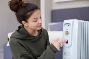 FEMALE USING HEATER INDOORS, HVAC AND PLUMBING SERVICES, ENERGY EFFICIENCY, COMFORT, MODERN HOME HVAC SYSTEM, HEATING SOLUTIONS, MY JOCKEY TOP-RATED HVAC AND PLUMBING.