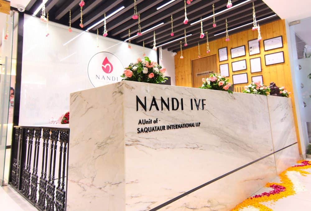 Nandi IVF clinic reception with marble counter and floral decor.