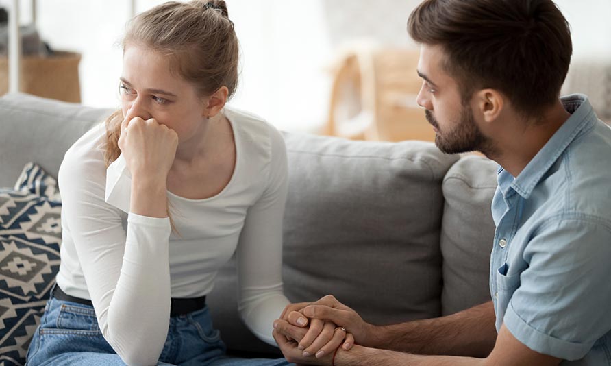 Couple discussing IVF treatment options with a doctor at home.