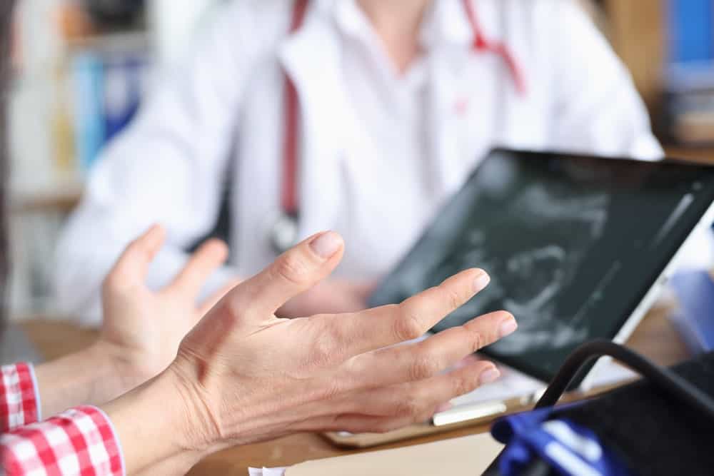 Doctor discussing fertility options with patient using tablet.