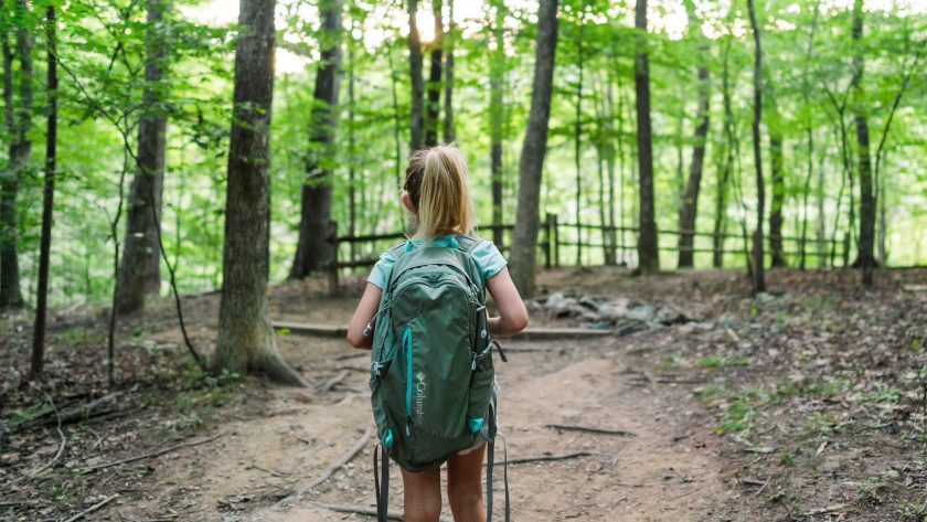 Low budget en gratis uitjes met kinderen in Nederland - meisje met rugzak in het bos