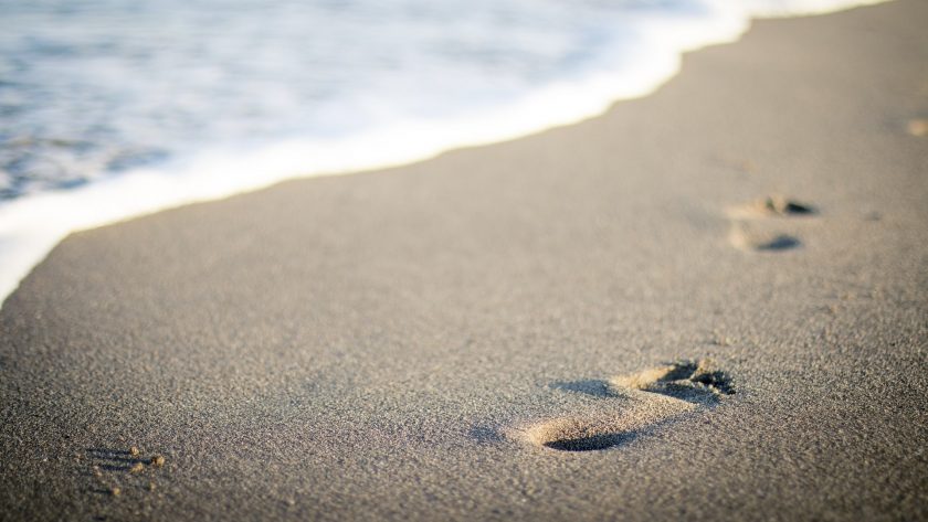 tips om duurzaam te reizen - laat geen afval achter, alleen je voetstappen op het strand