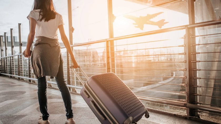 Inpaklijst: deze kleding neem ik mee op vakantie. Vrouw luchthaven trolley