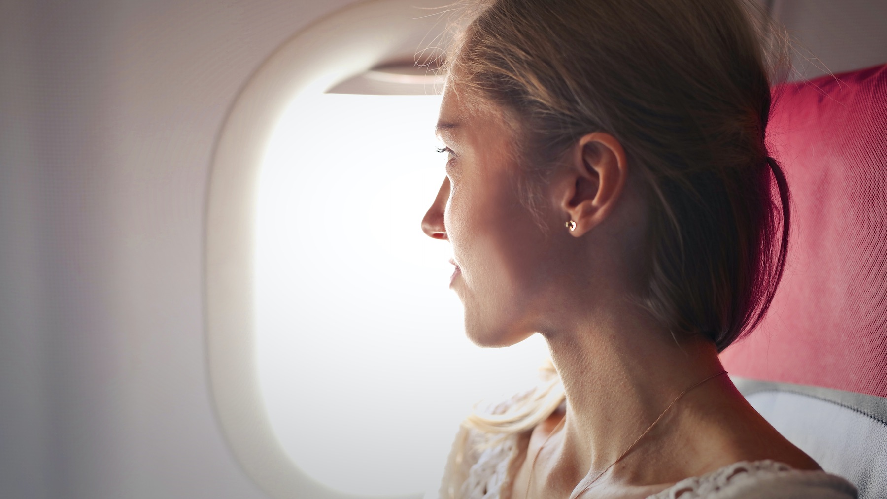 Welke kleding dragen in het vliegtuig? Woman Airplane window