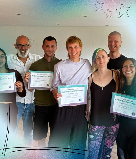 Sechs Personen stehen in einem Raum, vier von ihnen halten Zertifikate mit der Aufschrift Business Practitioner in der Hand und lächeln für ein Gruppenfoto.