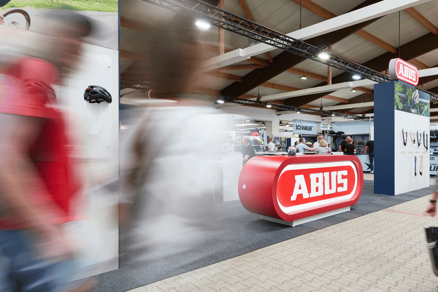 Abus Fahrradschloss-Ausstellung auf der Messe, Besucher in Bewegung.