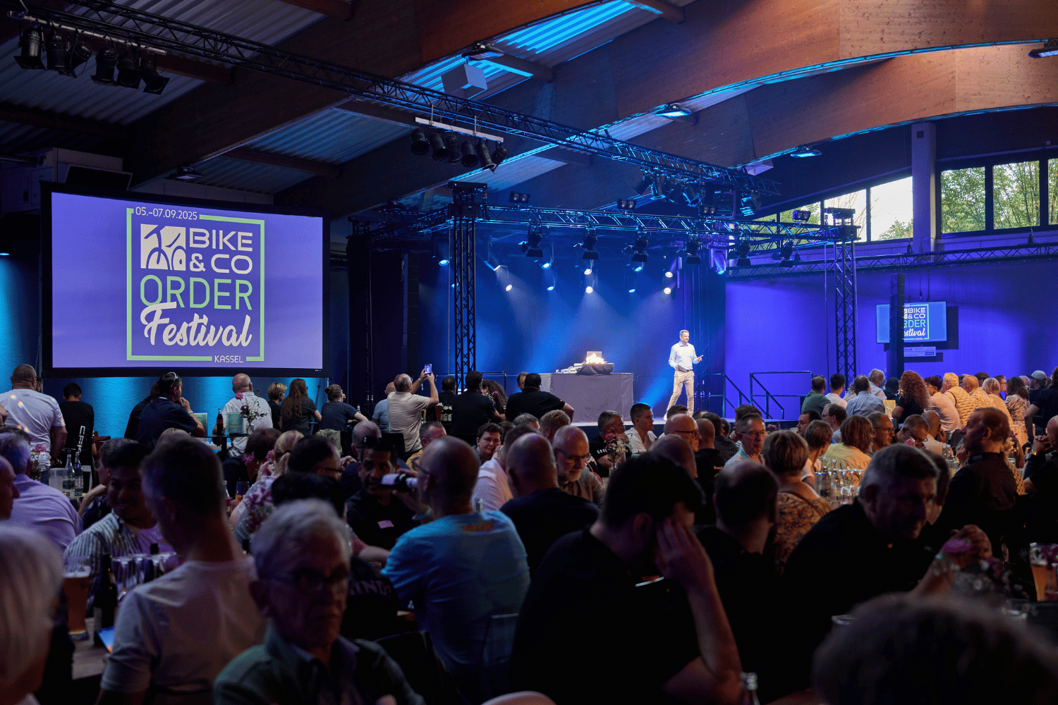 Menschen bei einem Fahrrad- und E-Bike-Festival in einem großen Veranstaltungsraum.