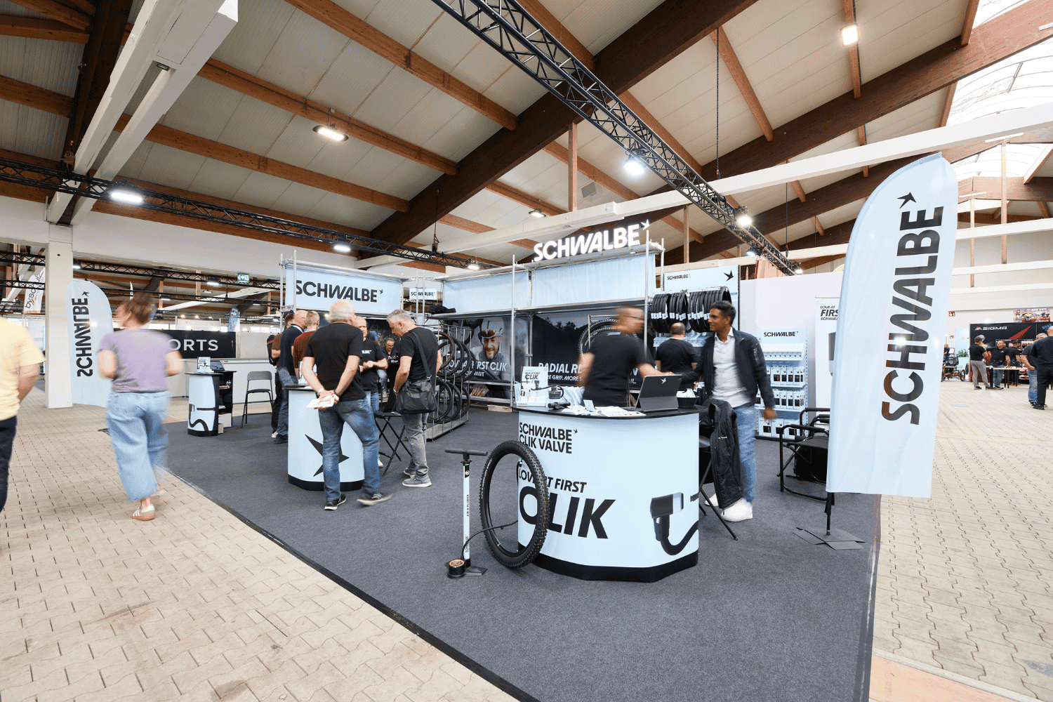 Schwalbe Messestand auf einer Fachmesse mit Besuchern und Produkten.
